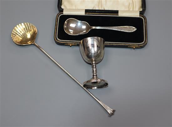 A cased silver spoon, a modern Asprey & Co stirring spoon with shell bowl and a white metal egg cup.